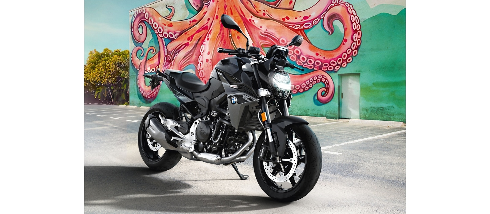 Vediamo una F 900 R Nera parcheggiata davanti ad un graffito che rappresenta un polipo arancione